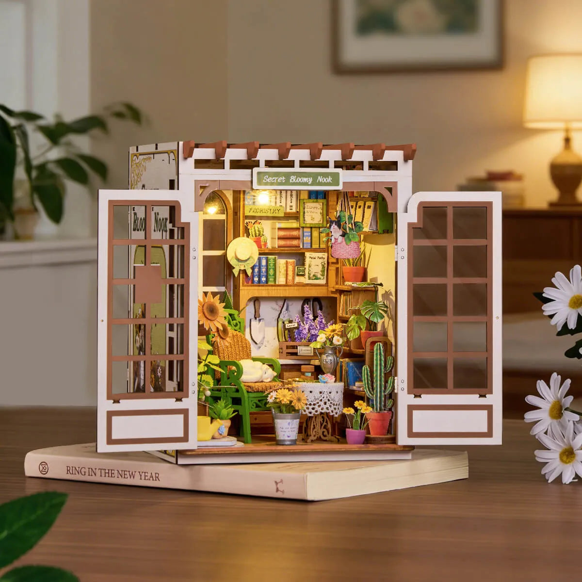 Secret Bloomy Nook iluminado sobre un libro, con las puertas abiertas.