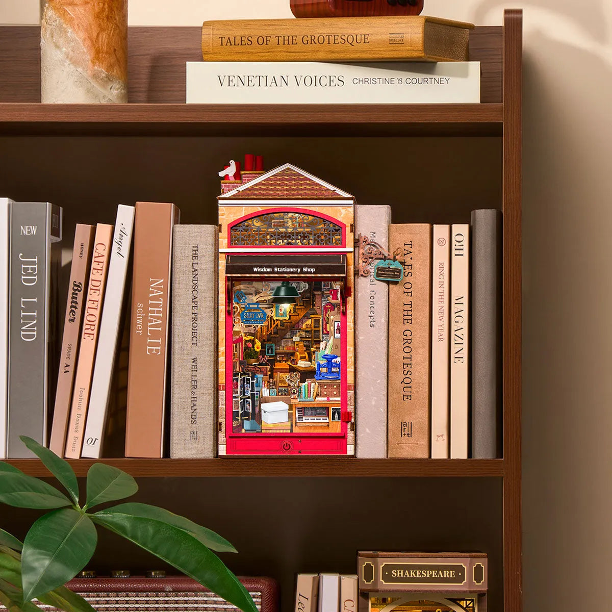 Wisdom Stationery Shop colocado entre libros en una estantería.