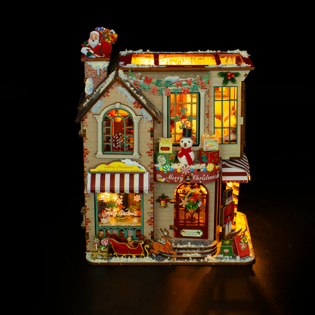 Enchanted Christmas Cottage de Hongda, iluminada sobre fondo oscuro