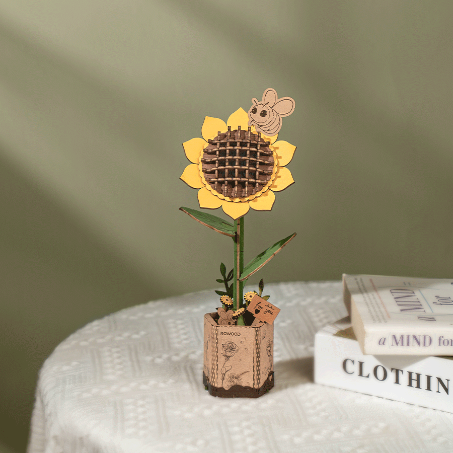 Girasol de madera junto a un libro en una escena de luz natural · Rowood