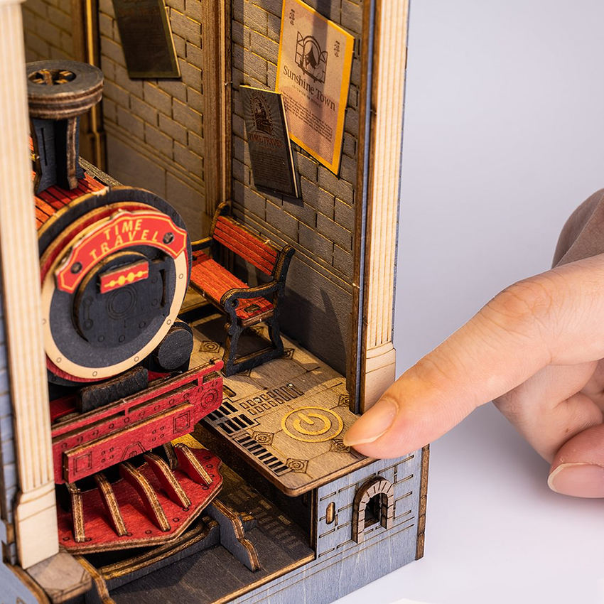 
Un dedo pulsa el control de la base junto a la locomotora de Time Travel.