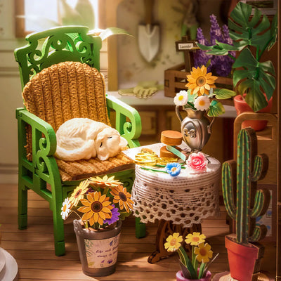 Detalle del gato dormido en el sillón y las macetas de Secret Bloomy Nook.