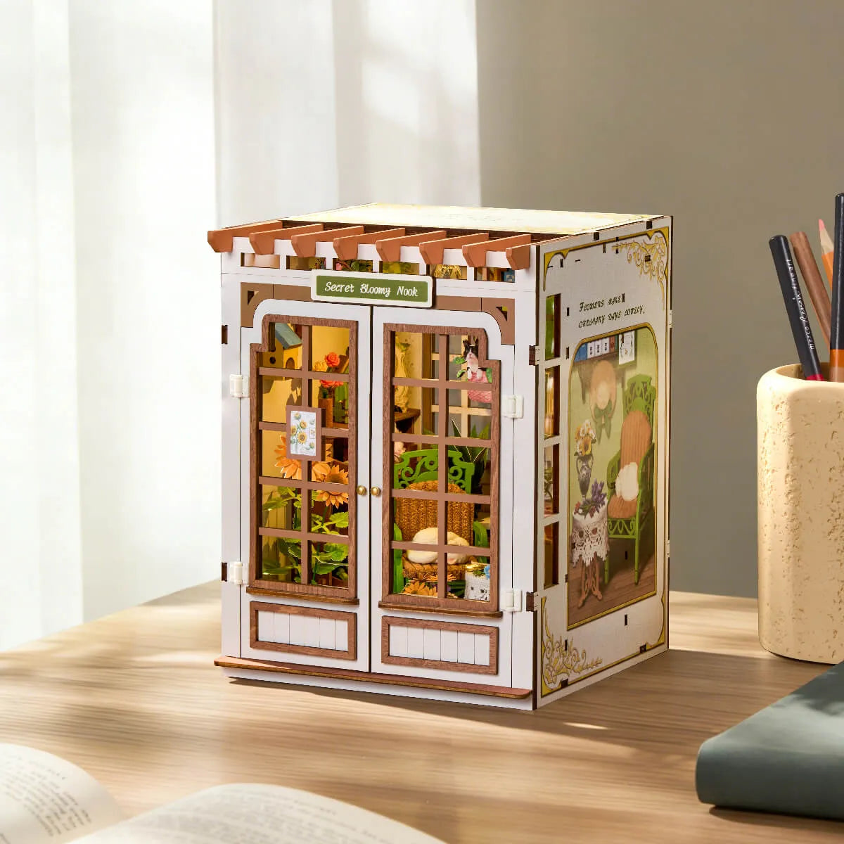
Secret Bloomy Nook con las puertas cerradas, sobre una mesa junto a la ventana.