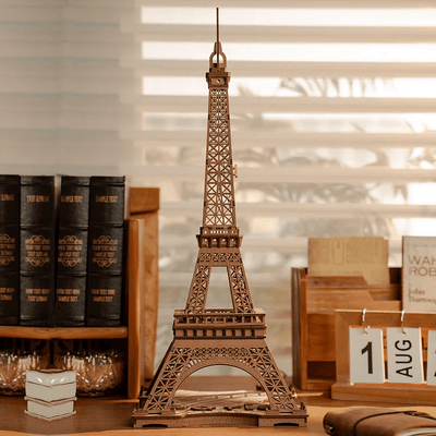 Torre Eiffel sin iluminar sobre una mesa junto a libros · Rolife
