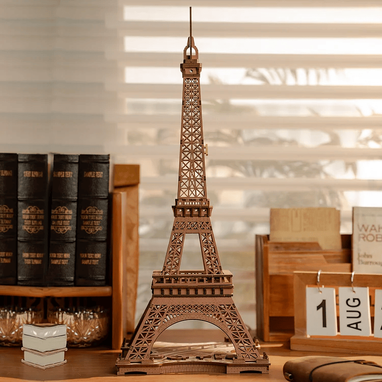 
Torre Eiffel sin iluminar sobre una mesa junto a libros · Rolife