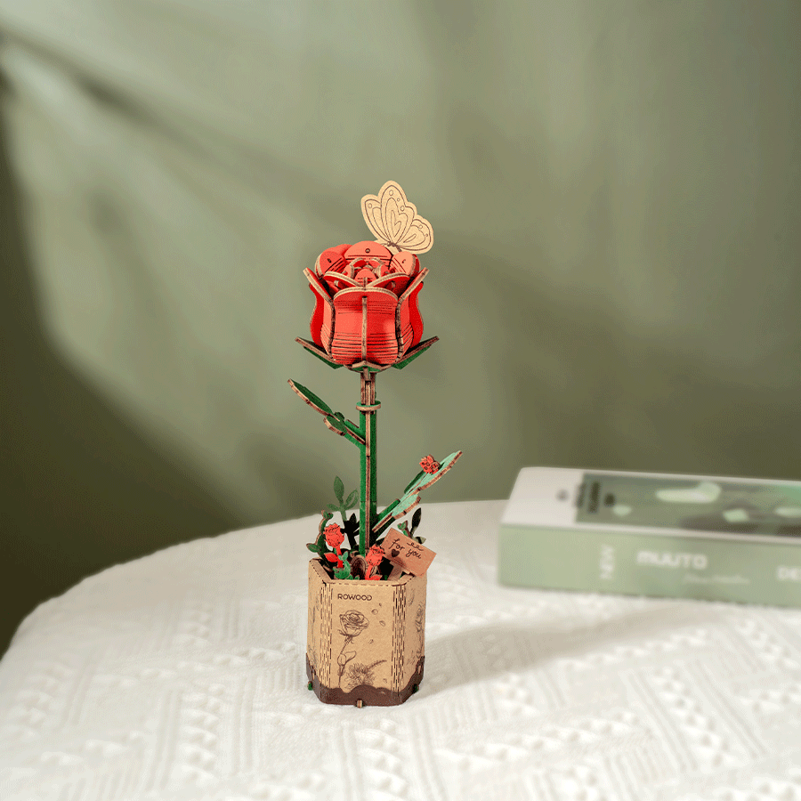 
Rosa roja de madera sobre una mesa con luz natural · Rowood