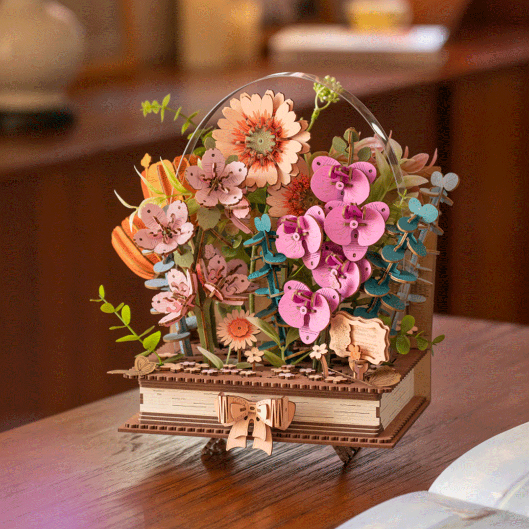
Libro de flores de madera sobre una mesa junto a un libro abierto · Rowood