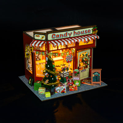 Candy House de Hongda, iluminada sobre fondo oscuro