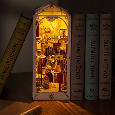 Sunshine Town iluminado en un ambiente oscuro, con la calle en miniatura entre libros.
